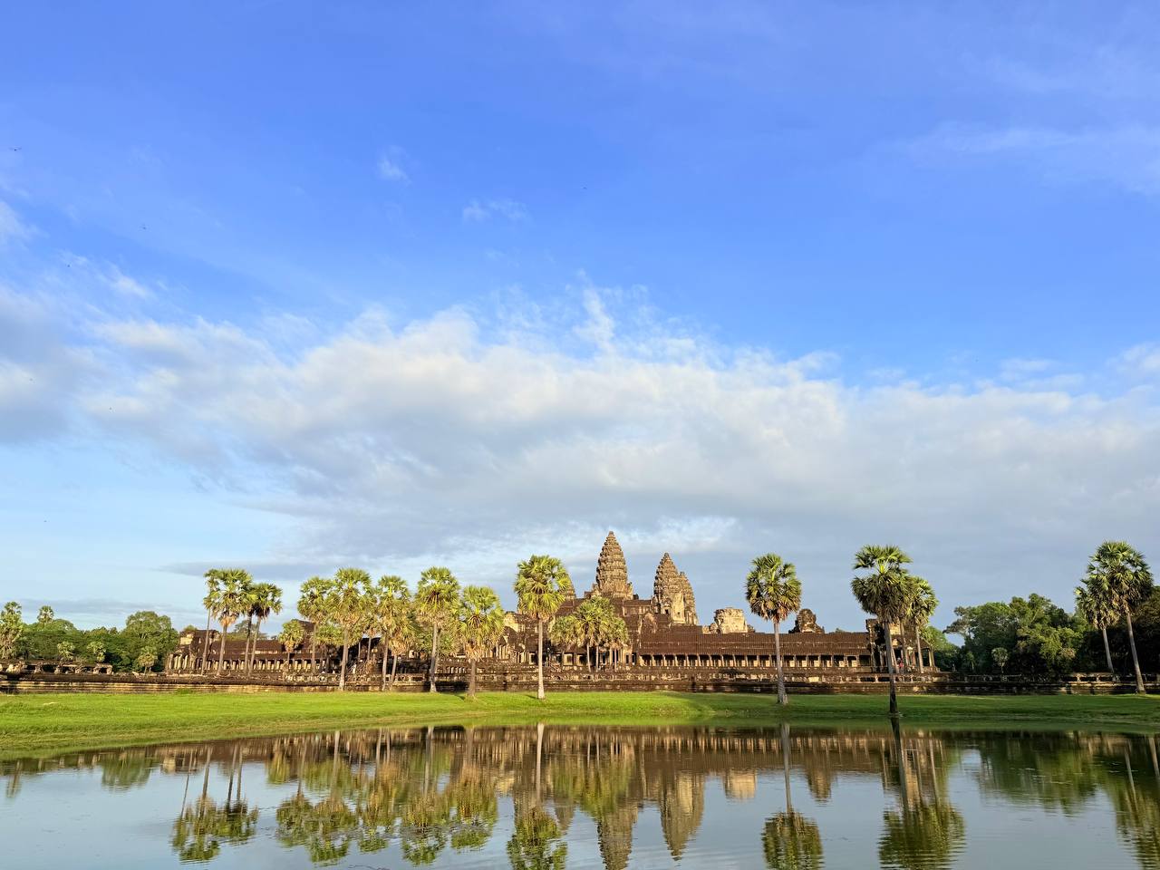 Angkor Wat reflected in the water beneath a blue sky