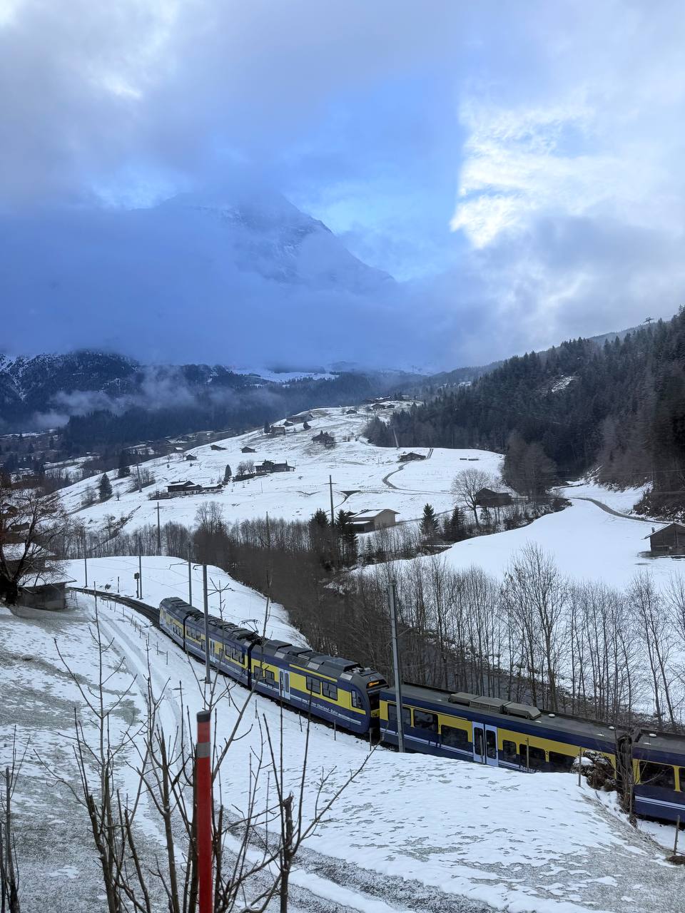 A train travelling through a snowy mountain village