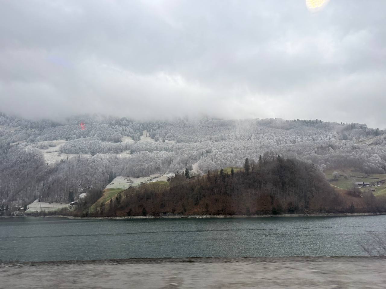 Snowy hills beside a lake on a cloudy day